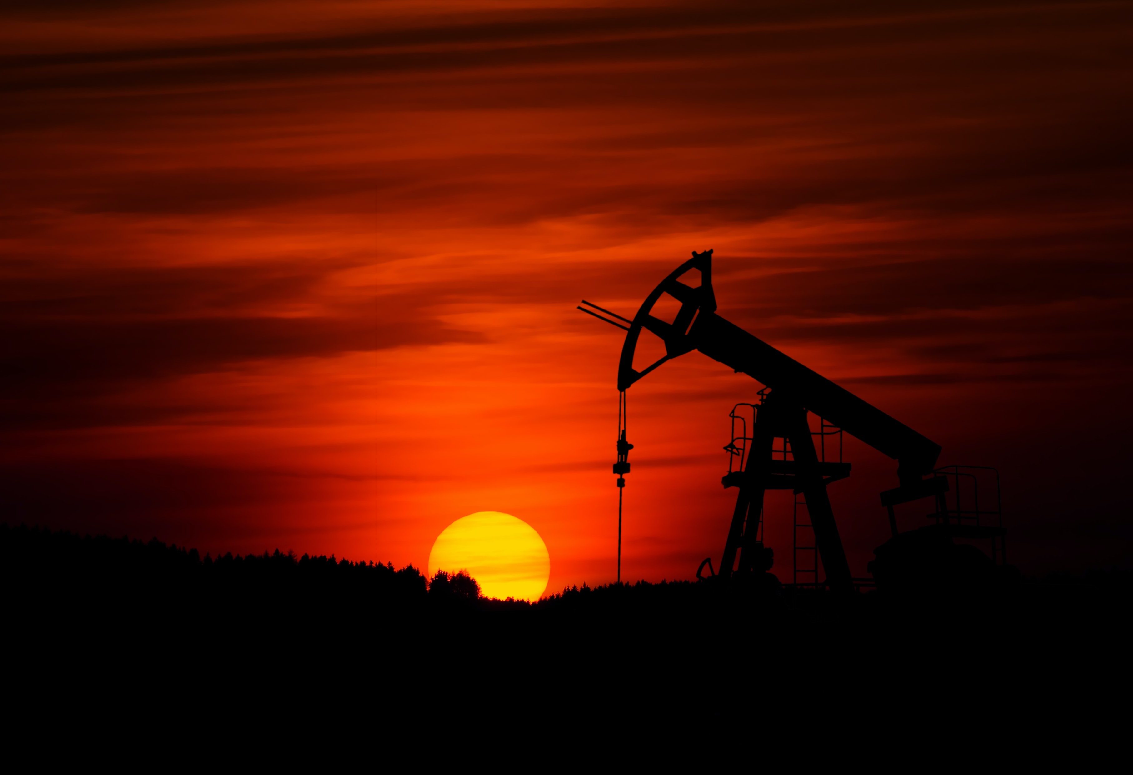 An Oil Derrick pumping Texas Oil Well with a beautiful Texas sunrise.